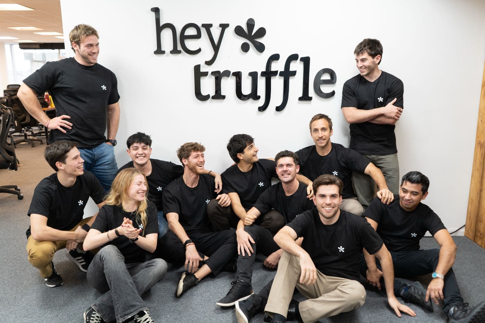 The full heytruffle team gathered in front of the office sign
